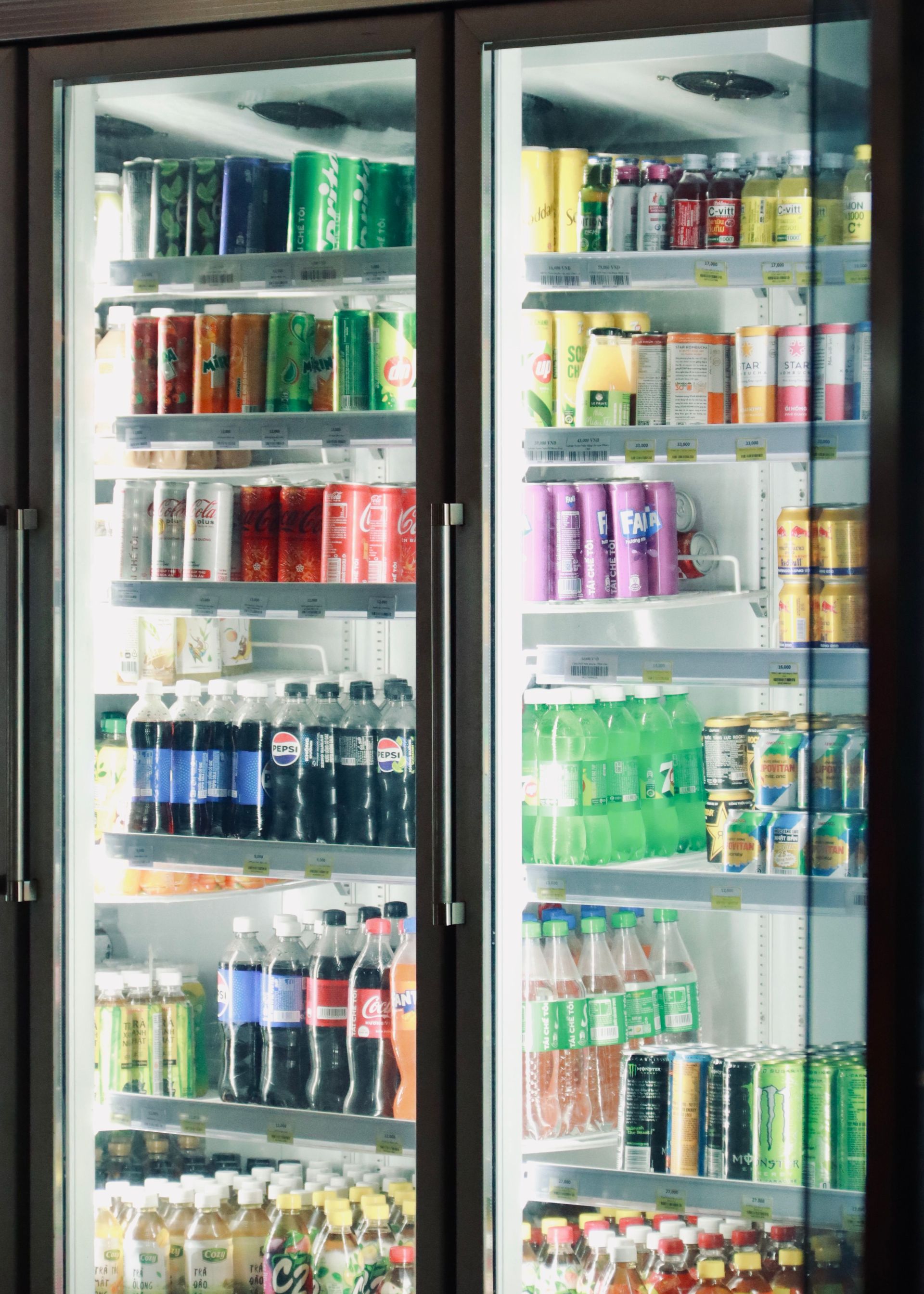 Various drinks on display in a refrigerated shelf. Bright and inviting beverage options.